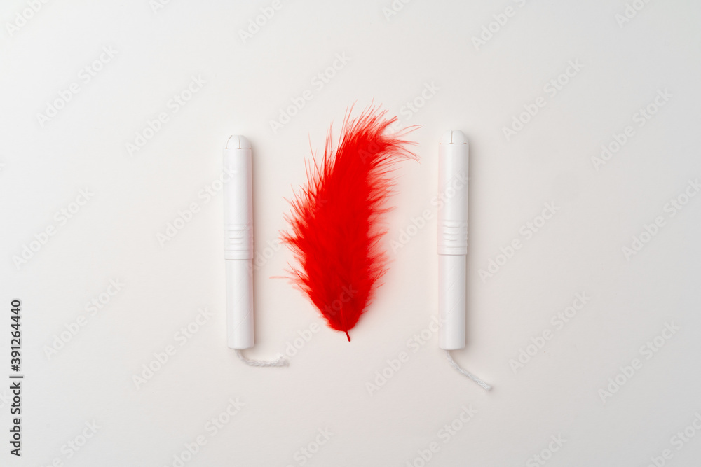 Red feather and woman medical tampon on white background Red feather and woman medical tampon on white background