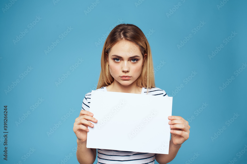 Emotional woman holding a sheet of paper in her hands lifestyle close-up blue background Copy Space Emotional woman holding a sheet of paper in her hands lifestyle close-up blue background Copy Space