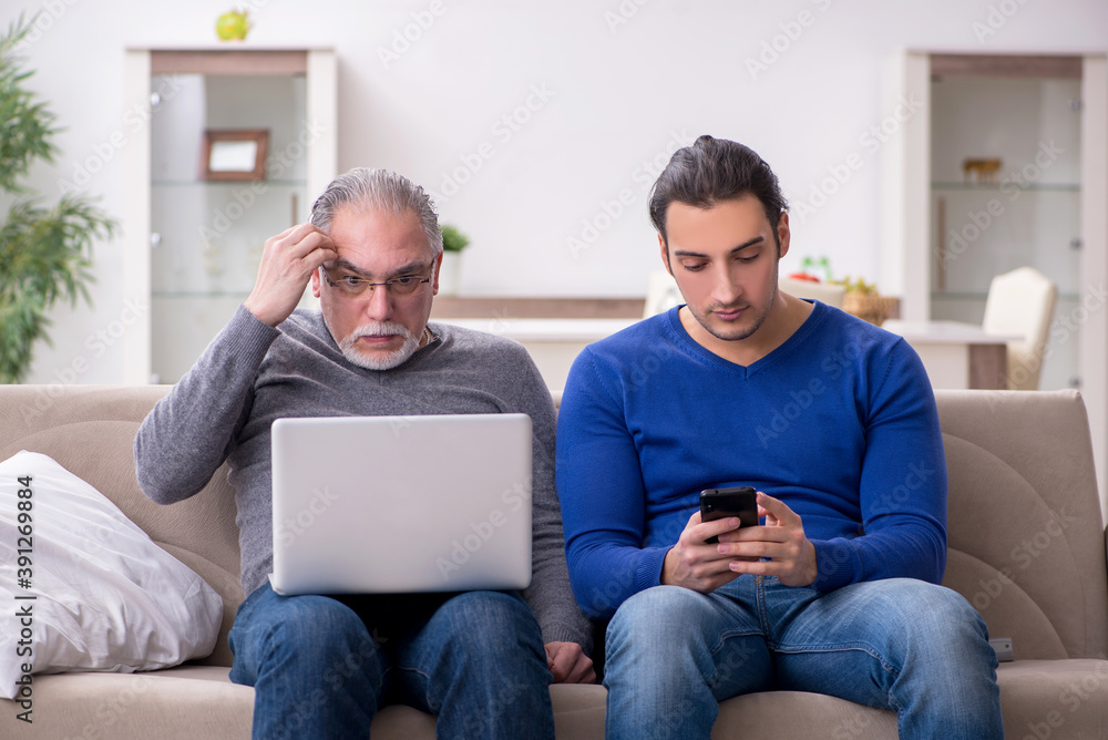 Father and son sitting on the sofa with computer Father and son sitting on the sofa with computer