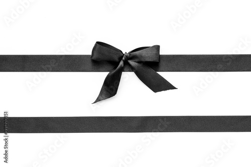 Festive black ribbon with bow isolated on white. Top view, copy space