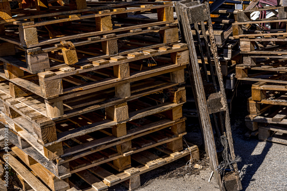 Many pallets stacked in stock, warehouse pallets. Old wooden material Many pallets stacked in stock, warehouse pallets. Old wooden material