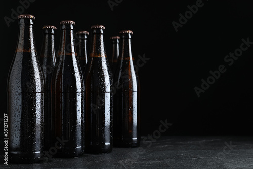 Bottles of beer on table against black background. Space for text