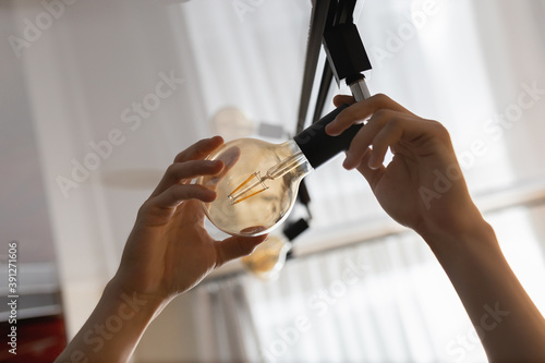 A man changes a burnt out light bulb at home