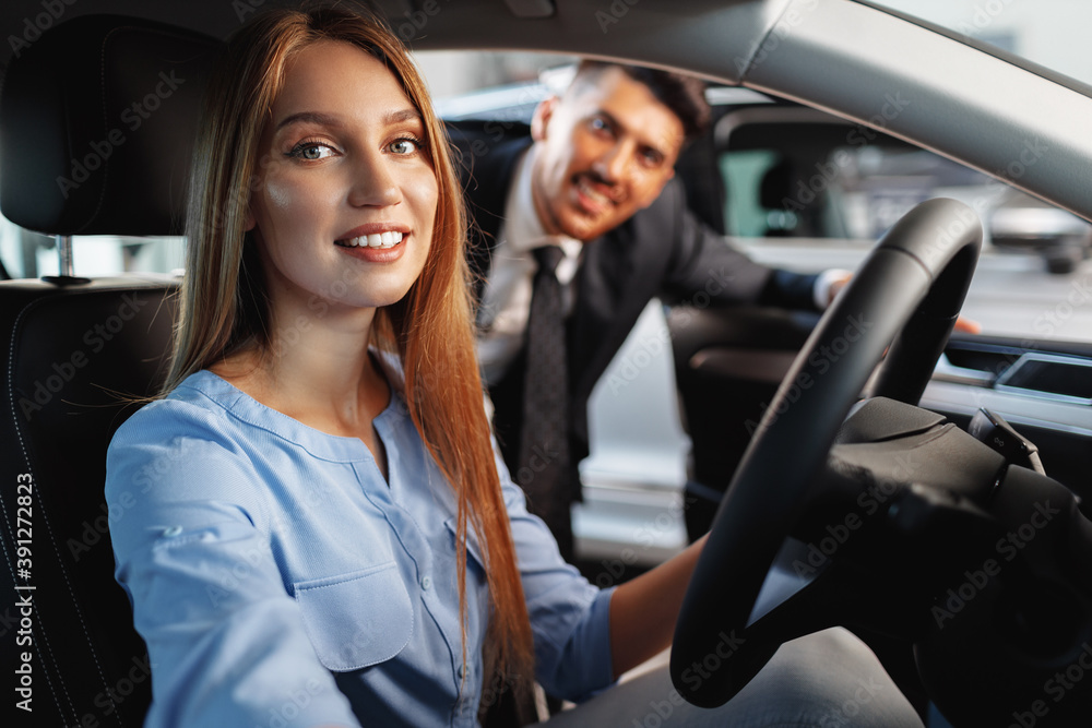 Happy woman new car owner sitting in driver seat