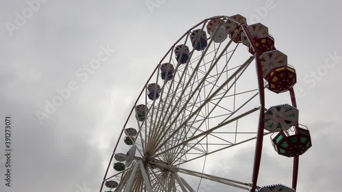 Ferris wheel in motion, cloudy sky background