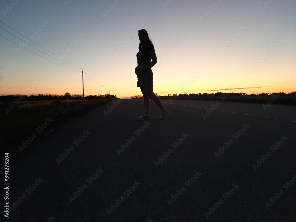 silhouette of a person walking on the road
