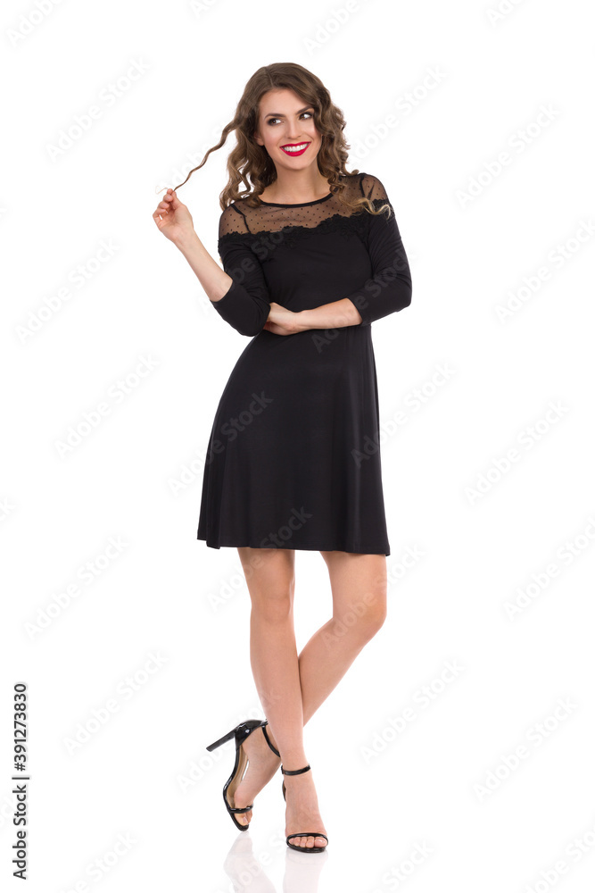 Young Woman In Elegant Black Dress Is Holding Lock Of Hair And Smiling Young Woman In Elegant Black Dress Is Holding Lock Of Hair And Smiling