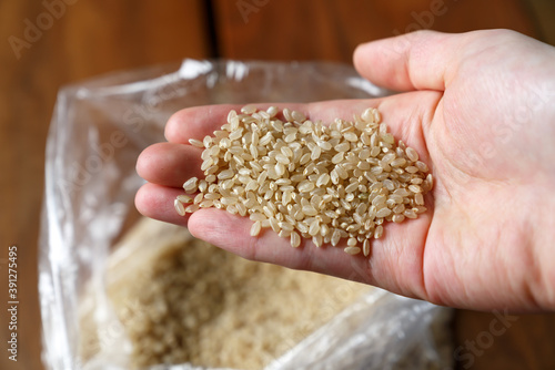 玄米の米粒を持つ手
