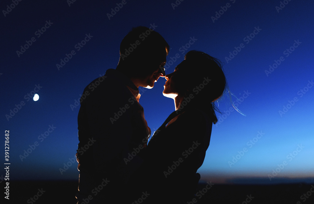 silhouette of smiling couple at night