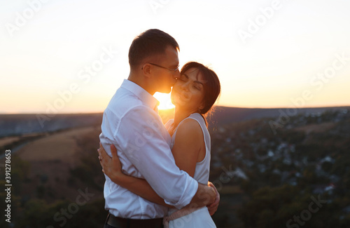 man kissing woman in cheek on hill