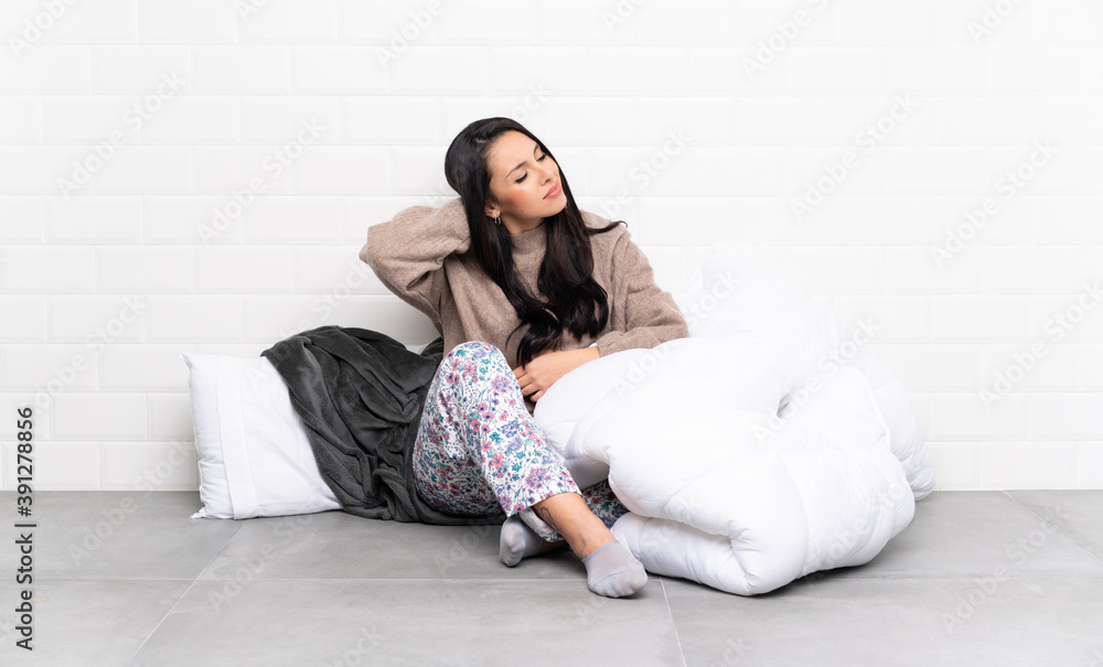 Young Colombian girl in pajamas at indoors with neckache Young Colombian girl in pajamas at indoors with neckache