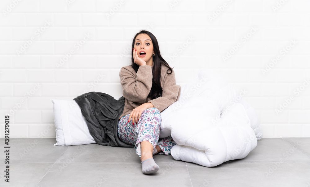 Young Colombian girl in pajamas at indoors surprised and shocked while looking right Young Colombian girl in pajamas at indoors surprised and shocked while looking right