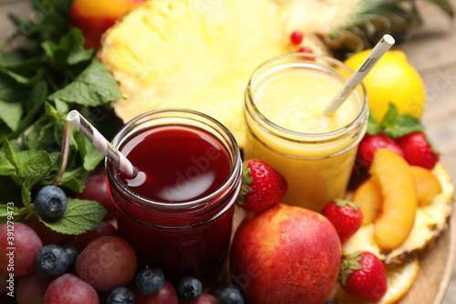Delicious colorful juices in glasses and fresh ingredients on table, closeup