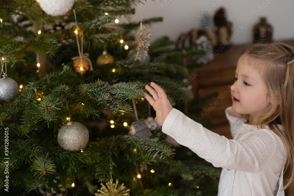 Girl decorates a tree for the Christmas