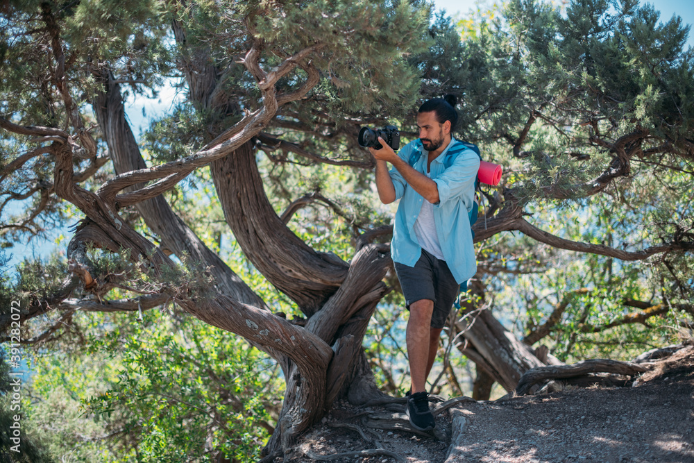 Male photographer with a camera on a hike.