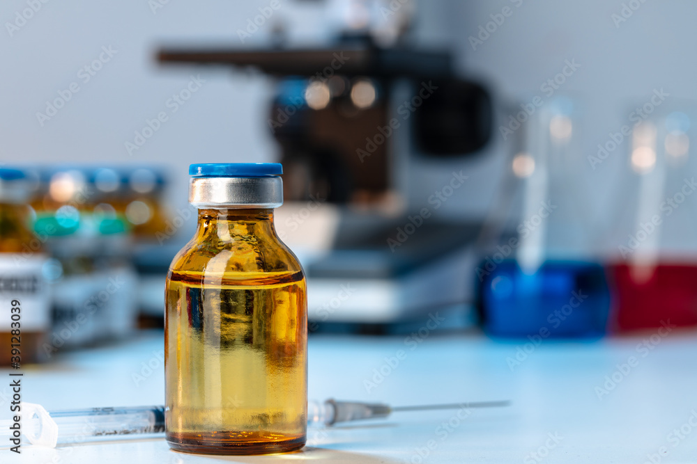 Medical vial with medication near microscope photo Medical vial with medication near microscope photo