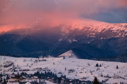 Winter sunset alpine top view from mountain village. Picturesque seasonal, nature and countryside beauty concept scene.