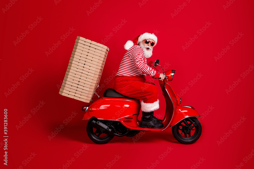 Full length profile photo of pensioner grandpa moped ride road deliver many pizza box wear santa x-mas costume suspenders sunglass boots striped shirt cap isolated red color background Full length profile photo of pensioner grandpa moped ride road deliver many pizza box wear santa x-mas costume suspenders sunglass boots striped shirt cap isolated red color background
