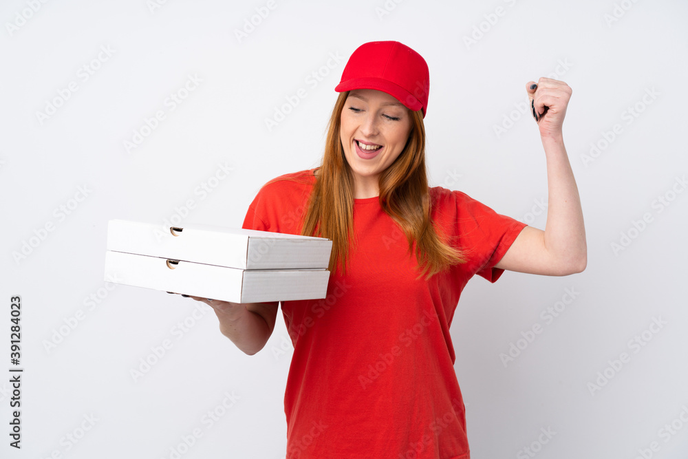 Pizza delivery woman holding a pizza over isolated pink wall celebrating a victory Pizza delivery woman holding a pizza over isolated pink wall celebrating a victory