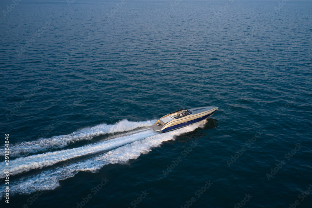 Large speedboat moving at high speed.  The boat is gray-blue combined color. Large speed boat moving at high speed side view.