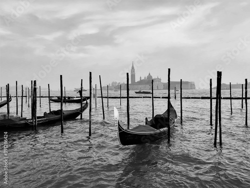 Venice, Italy, December 28, 2018 evocative image of a gondola moored with San Giorgio island in the background   © massimo