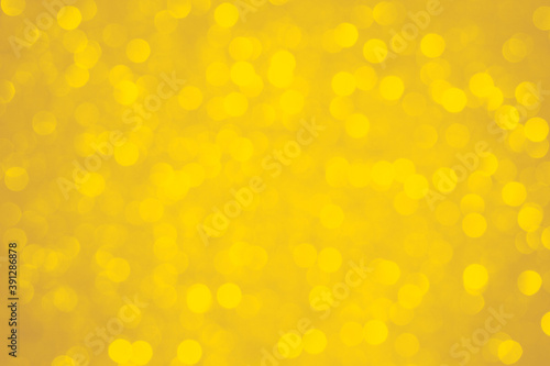 Holiday sparkles background, blurred light yellow mustard background