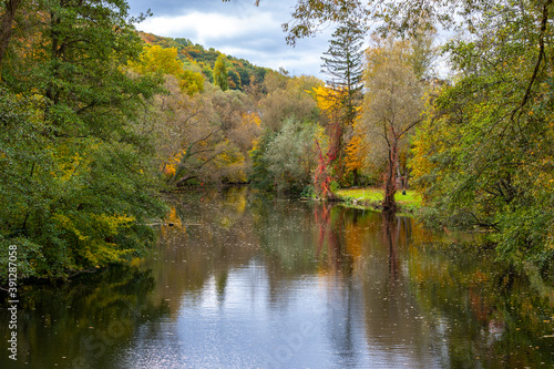 Fototapeta Naklejka Na Ścianę i Meble -  River Glan surrounded with multi colored trees