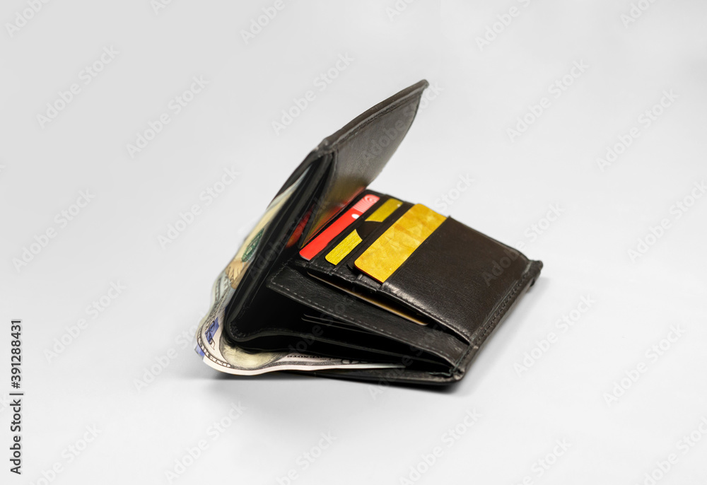 Wallet with a hundred dollar bill and credit cards on a gray background Wallet with a hundred dollar bill and credit cards on a gray background