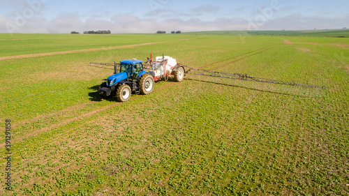 Tablou pe pânză Wide angle image of a crop spray machine spraying chemicals on wheat crop on a f