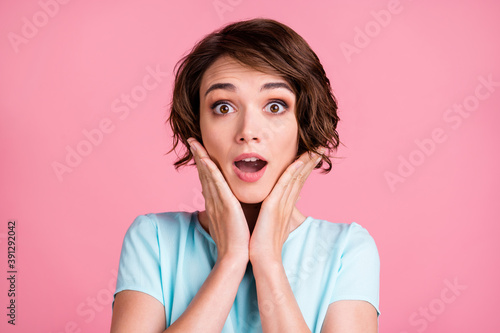 Photo of surprised cute woman wear casual blue t-shirt arms cheeks open mouth isolated pink color background