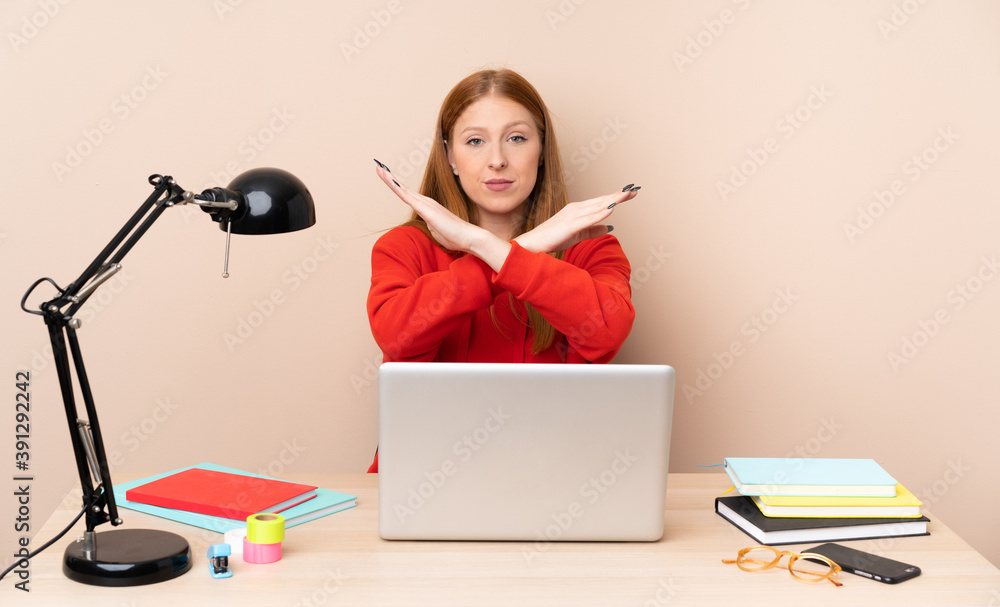 Young student woman in a workplace with a laptop making NO gesture Young student woman in a workplace with a laptop making NO gesture