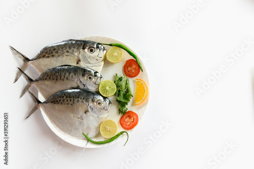 Fresh Razor moonfish/Razor Trevally Fish, Decorated with herbs and lemon slice on a white plate.Space for Text. photo