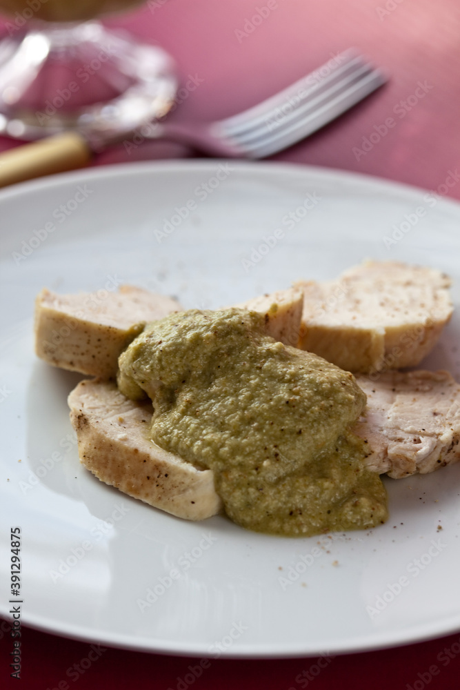 Chicken with green pipian served on white plate Chicken with green pipian served on white plate