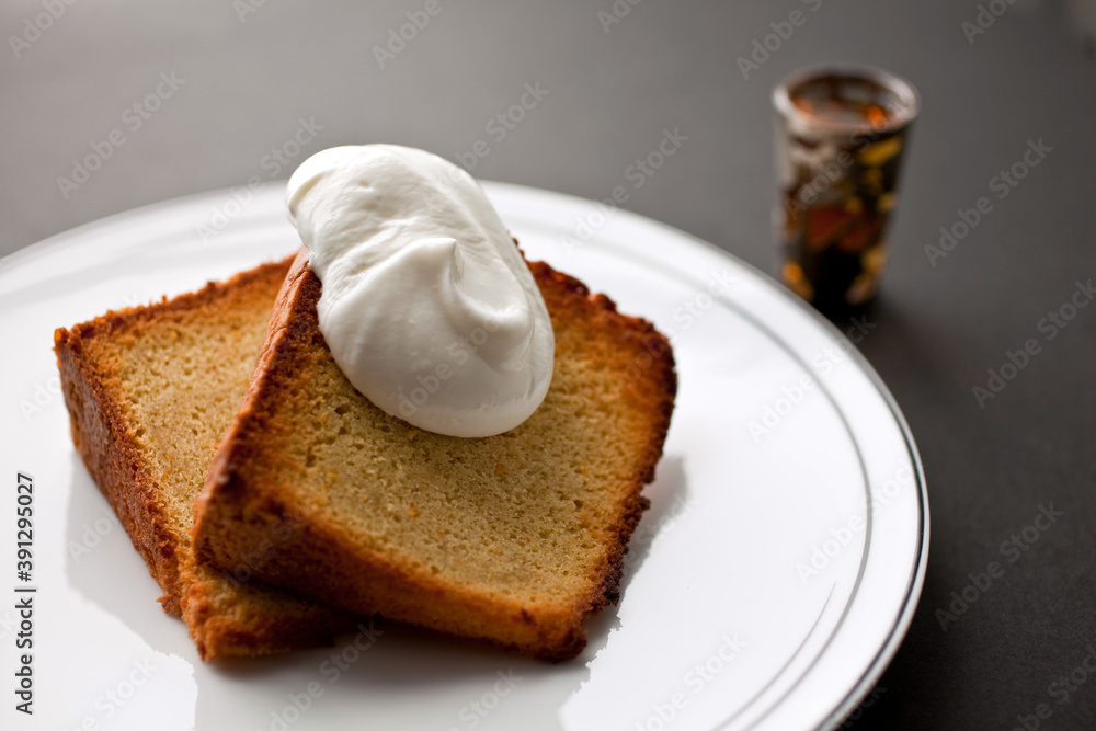 Close up of orange savarin cake with cream on plate Close up of orange savarin cake with cream on plate