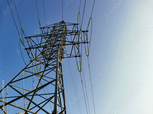A high voltage power transmission line on the clean blue sky background