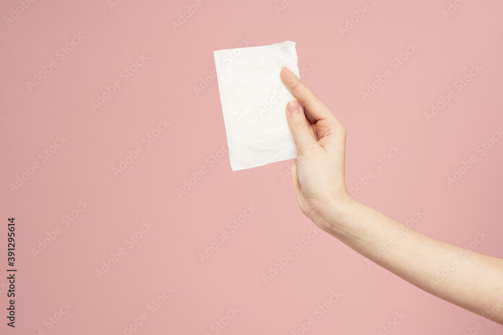 Laying in packaging in female hands on a pink background cropped view hygiene clean appearance Laying in packaging in female hands on a pink background cropped view hygiene clean appearance