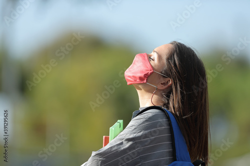Student with mask breathing fresh air in a park