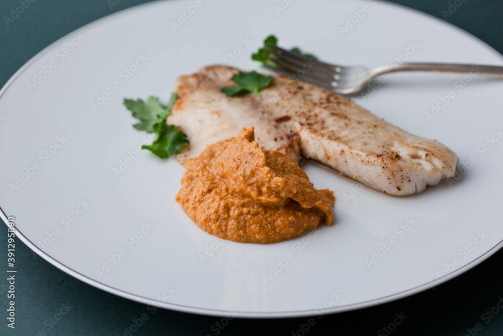 Spanish Romesco sauce served with Tilapia fish on plate Spanish Romesco sauce served with Tilapia fish on plate