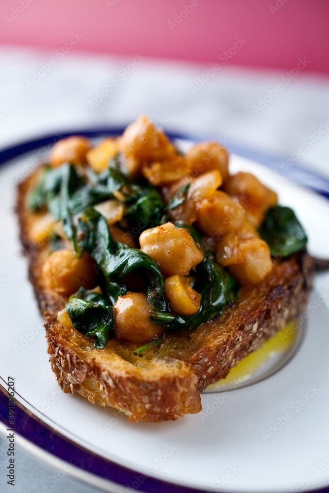 Close up of bruschetta with chickpea and baby spinach Close up of bruschetta with chickpea and baby spinach