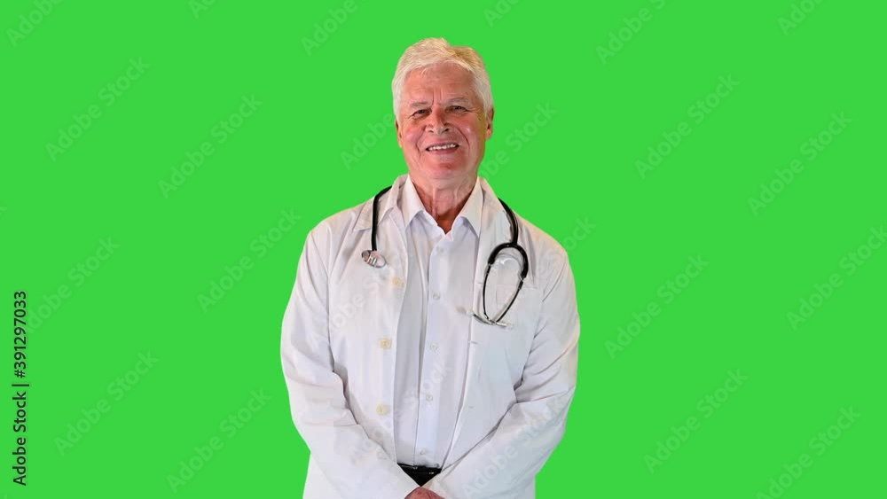 Old Male Doctor with a Stethoscope around His Neck Smiling to camera on a Green Screen, Chroma Key. Old Male Doctor with a Stethoscope around His Neck Smiling to camera on a Green Screen, Chroma Key.