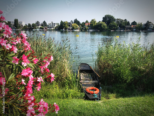 Photography Old wooden rowing boat on river banks of Alte Donau river in Vienna, Austria