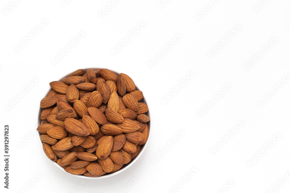 Almond nuts in white bowl on isolate white background,vegetarian food,top view,flat lay,top down,selective focus. Almond nuts in white bowl on isolate white background,vegetarian food,top view,flat lay,top down,selective focus.