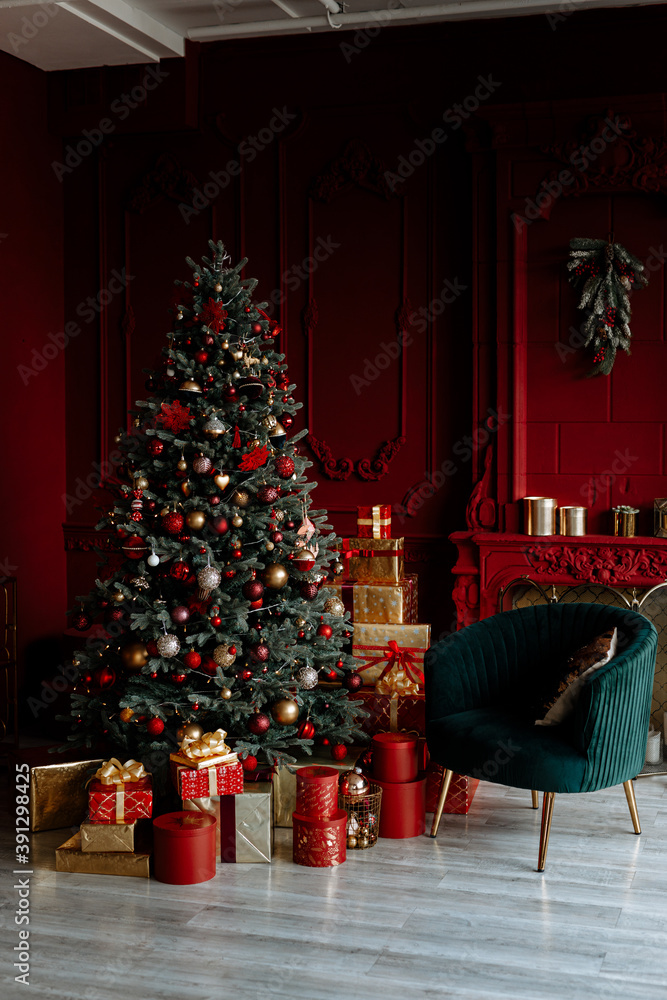 Beautiful festively decorated room with a Christmas tree. Cozy living room in red tones with a stylish classic decor.