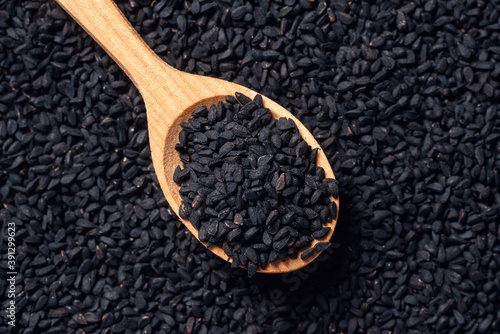 Obraz na płótnie Black cumin seeds on wooden spoon on wooden background