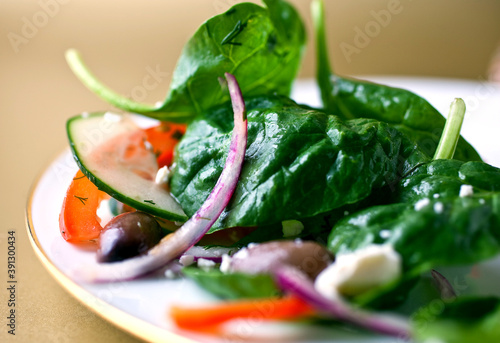 Close up of spinach salad with tomatoes, cucumber and feta cheese photo