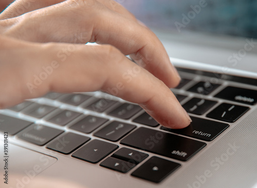 close up. man pressing the enter key on his laptop.