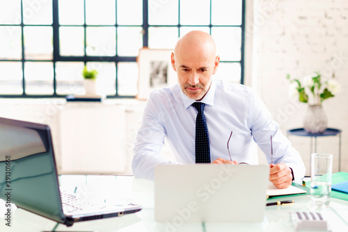 Portrait shot of stressed businessman working on laptop at the office
