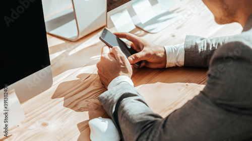 business man with smartphone sitting at Desk