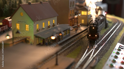 Replica model of railway station. Coming lokomotive train.