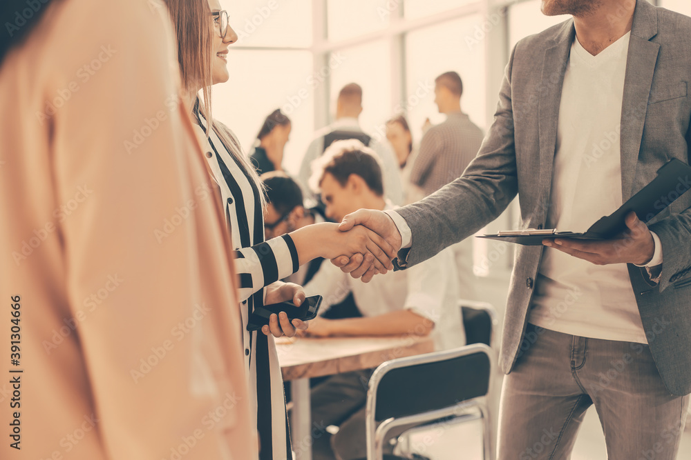 close up. Manager shaking the hand of a young business lady close up. Manager shaking the hand of a young business lady